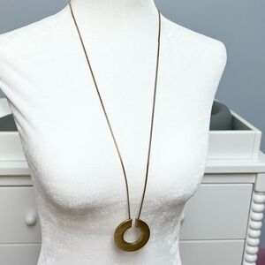 Gold tone metallic open disc pendant necklace on gold tone cord chain